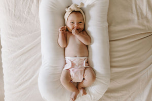 Newborn baby in pink reusable cover diaper 